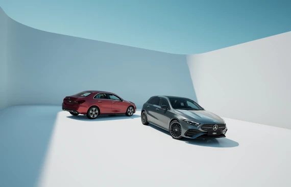Zwei Mercedes-Benz A-Klasse Fahrzeuge, ein rotes und ein graues, stehen in einem minimalistischen, weißen Studio.